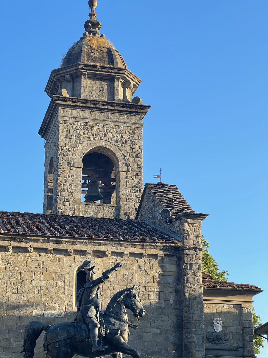 Bell tower of the Pieve di Santa Maria Assunta in Gavinana with the Ferrucci equestrian statue