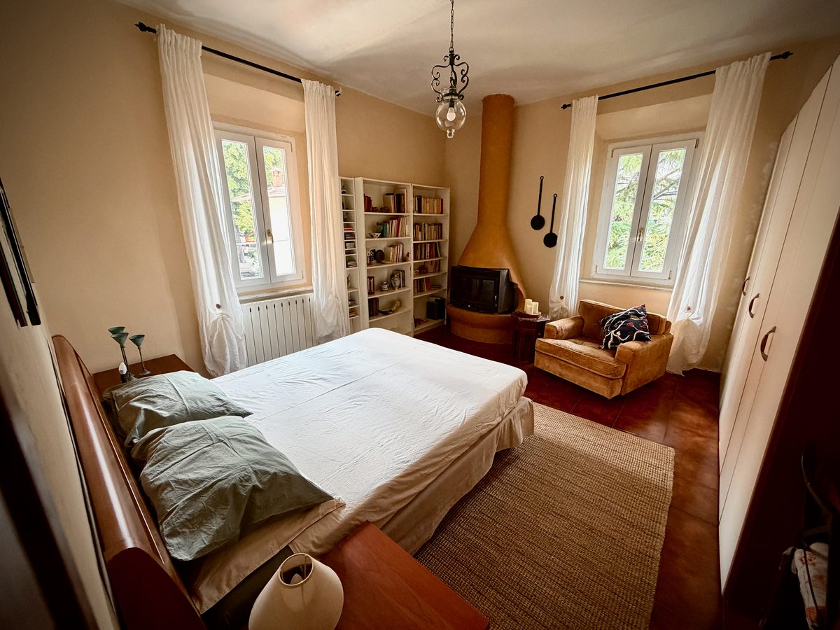 Hauptschlafzimmer der Ferienwohnung il Loft mit Terrakotta-Kamin und Sitzecke