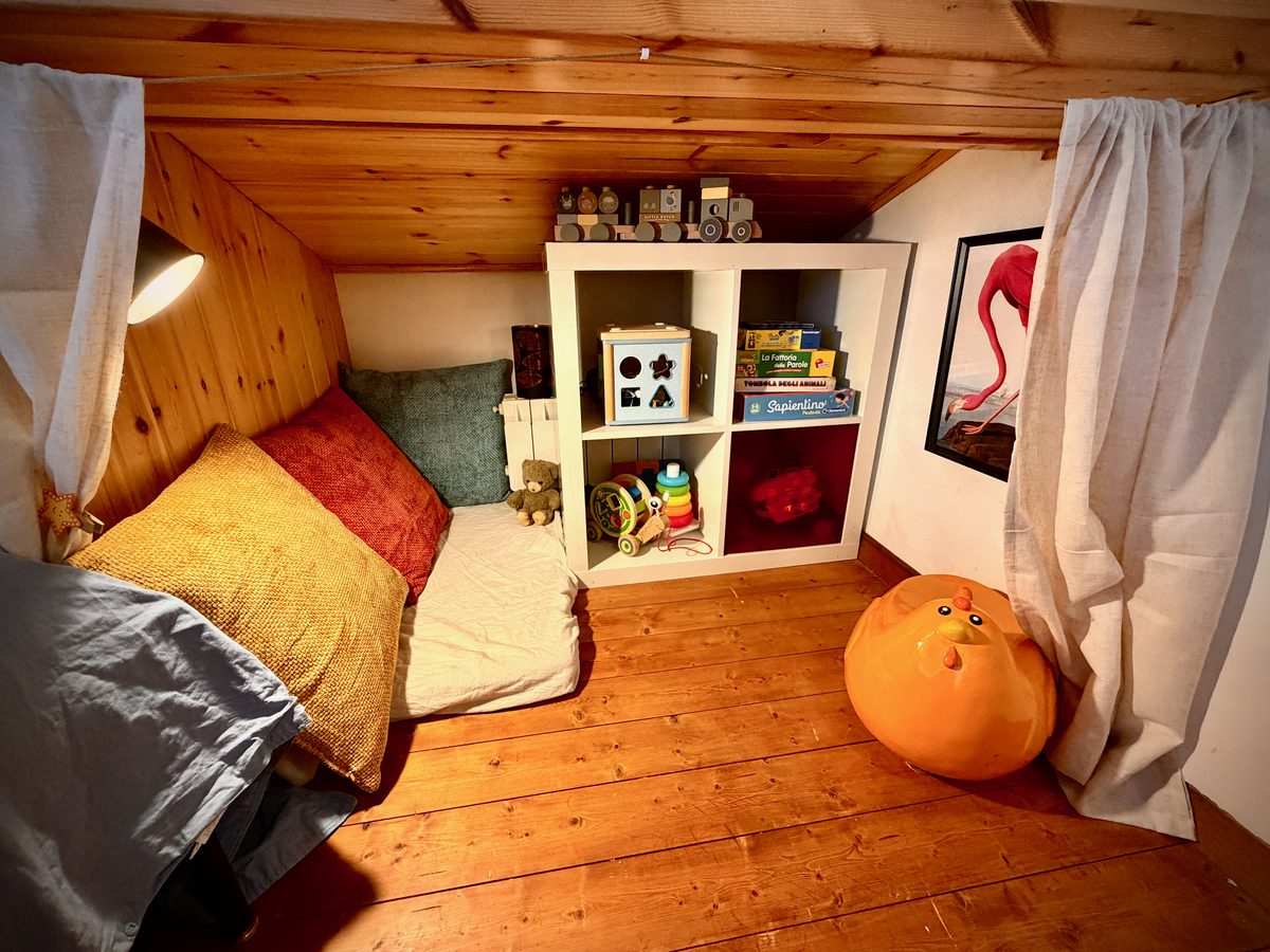 Gemütliche Leseecke im Kinderzimmer von il Loft mit Spielzeugregal
