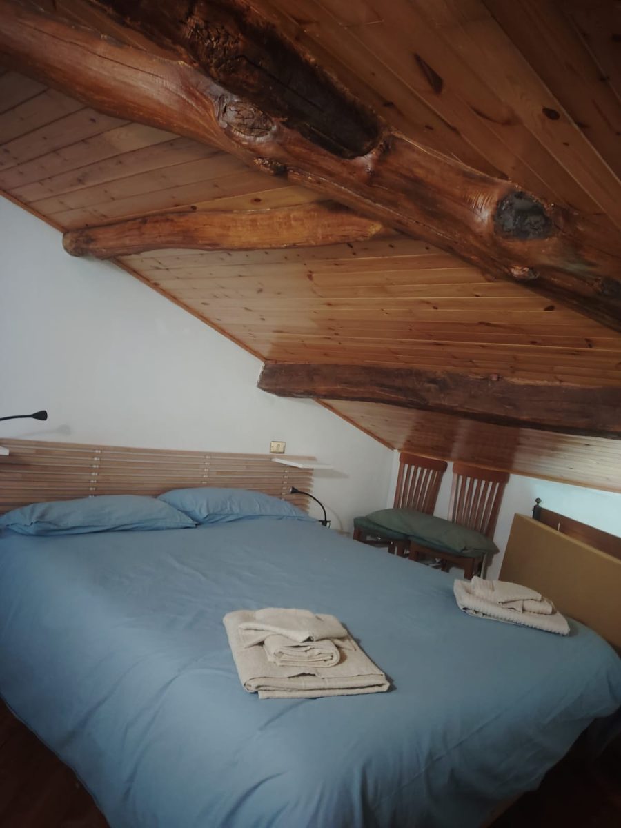 Loft bedroom under hand-crafted wooden beams