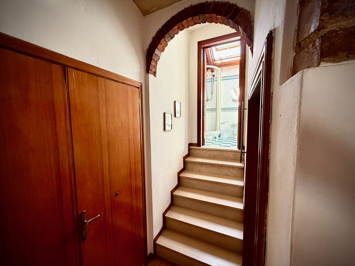 Staircase with brick archway to the bathroom