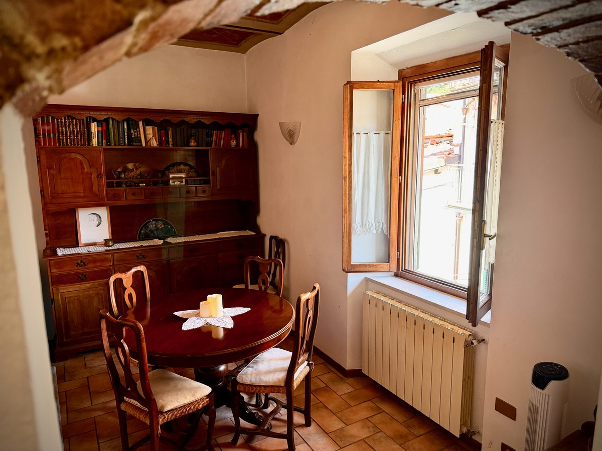 Dining area with antique Tuscan wooden sideboard and round table