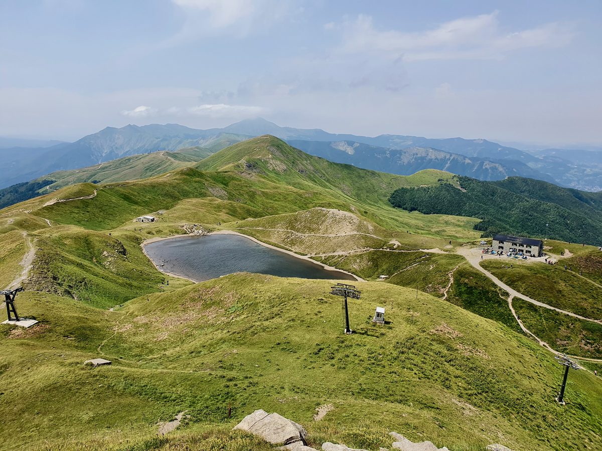 Blick über den Lago Scaffaiolo auf 1775 Metern im Appennino Tosco-Emiliano mit dem Rifugio Duca degli Abruzzi auf dem Hügelkamm dahinter