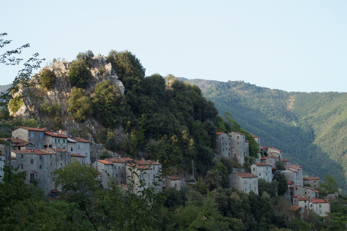 Das Bergdorf Lucchio zieht sich im Abendlicht an einem Felsgrat über der Val di Lima entlang, Provinz Lucca, Toskana
