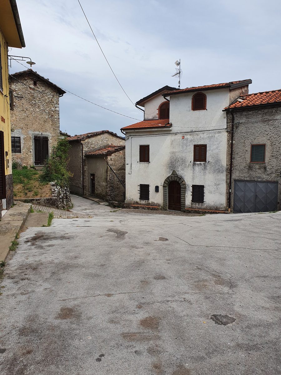 Schmale Gasse mit alten Steinhäusern im Bergdorf Lucchio, Provinz Lucca